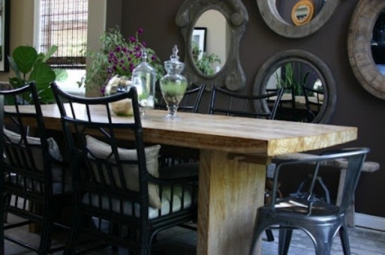 a vintage meets shabby chic dining room with an arrangement of mirrors, a wooden table and mismatching black chairs