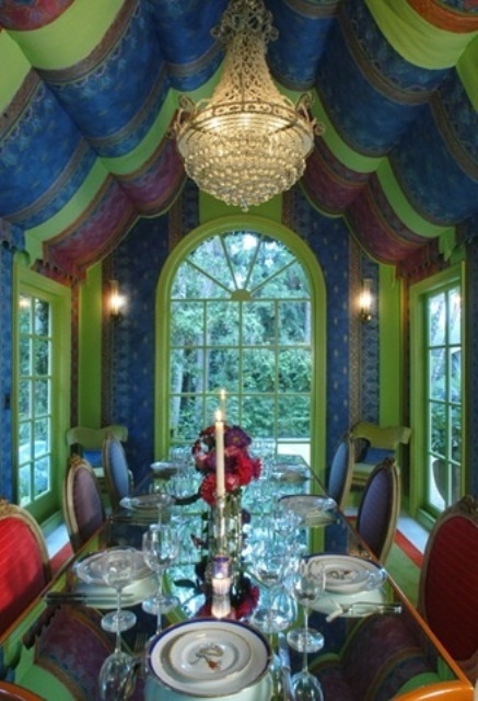 a chic and colorful dining room with refined furniture and a unique fabric canopy