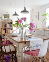 a bright rustic boho dining space with a rustic table, wood and whte plastic chairs and colorful textiles