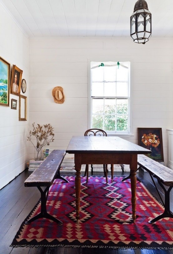 a bright boho dining space with a bold Moroccan rug, dark stained furniture and a pendant Moroccan lamp