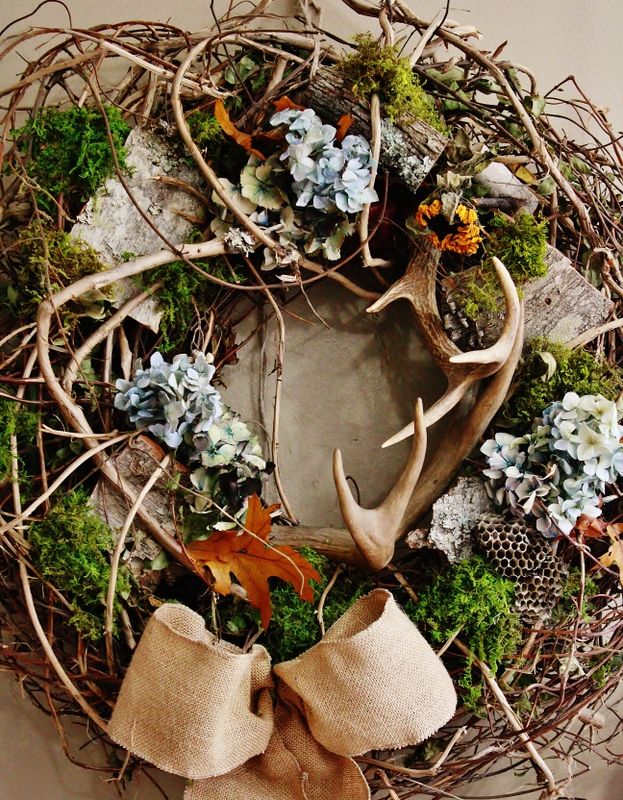 a very textural twig fall wreath with antlers, moss, dried blooms, burlap and a burlap bow will bring a woodland feel to your space