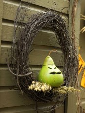 a creative twig wreath with a cutout pear and some wheat is a bold idea that looks unusual