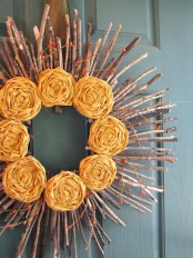 a stick and twig fall wreath with berries and orange fabric flowers is a creative rustic decoration
