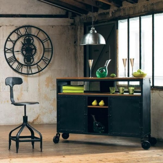 an industrial home bar made of a blackened metal storage unit, bold glasses and decanters, a metal stool and a metal lamp over the bar