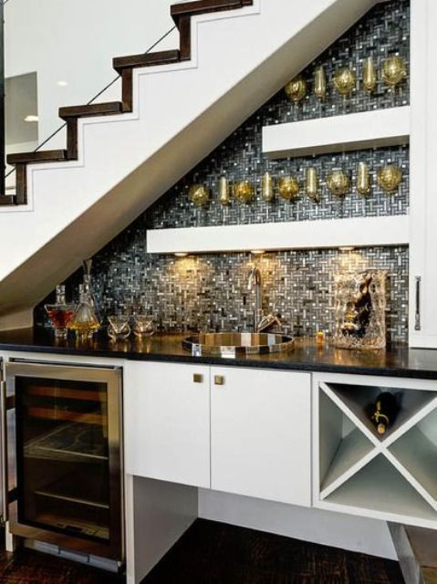 an under stairs home bar with a built-in storage unit and a fridge, open shelves, shiny tiles and built-in lights