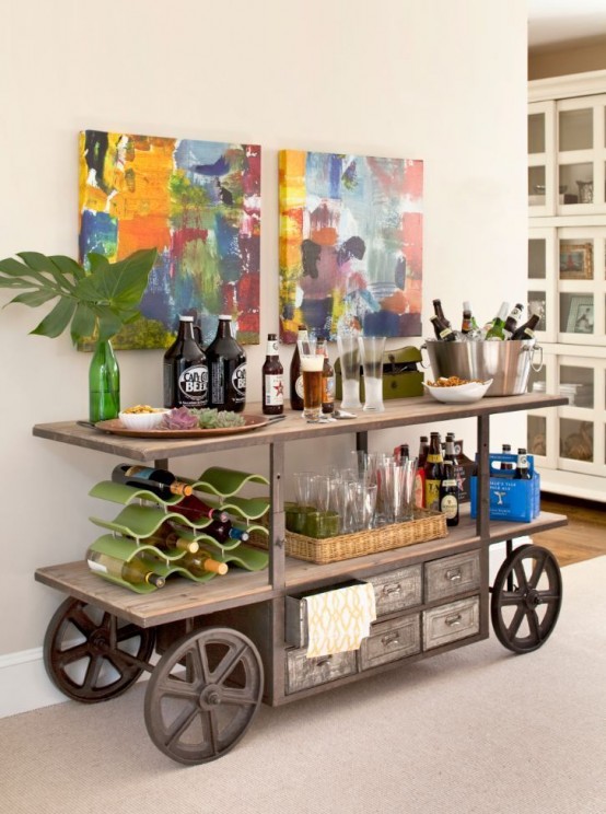a rustic vintage home bar on wheels, with wine bottles, glasses and bold artwork over it is a unique idea to give a rustic touch to the space