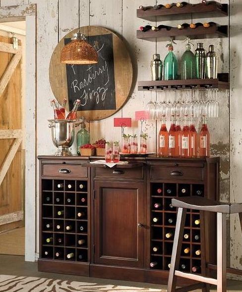 a dark-stained rustic home bar with a large storage unit and some open shelves, a chalkboard menu and other pretty decor for a vintage rustic space