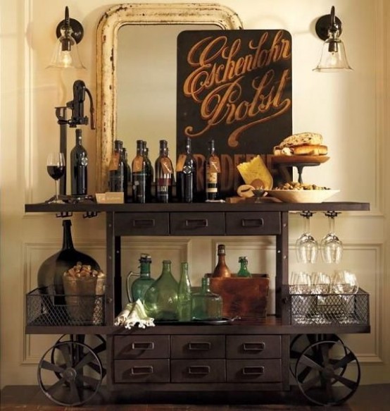 a vintage home bar space with a large mirror, lights and art, a metal home bar on wheels, lots of bottles, glasses and baskets is a chic and statement idea for a vintage space
