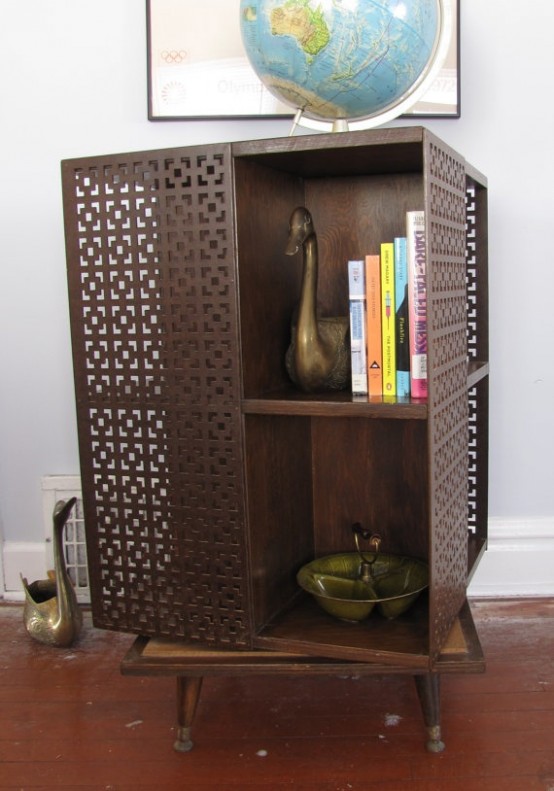 a dark-colored mid-century modern bookcase with laser cut doors and shelves inside