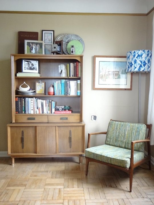 a neutral-colored wooden bookcase with open shelves, some drawers and a cabinet space is traditional for mid-century modern spaces