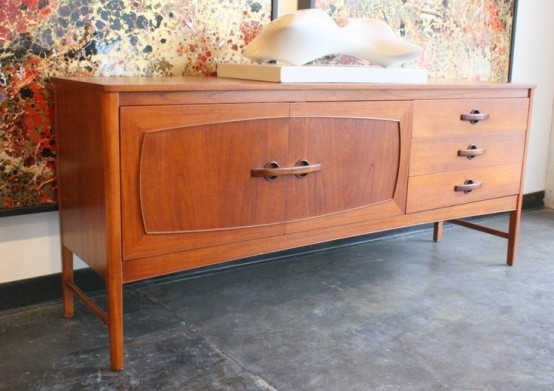a rich-stained sideboard with catchy carved doors and drawers with elegant handles is a lovely idea to give a mid-century modern feel to the space