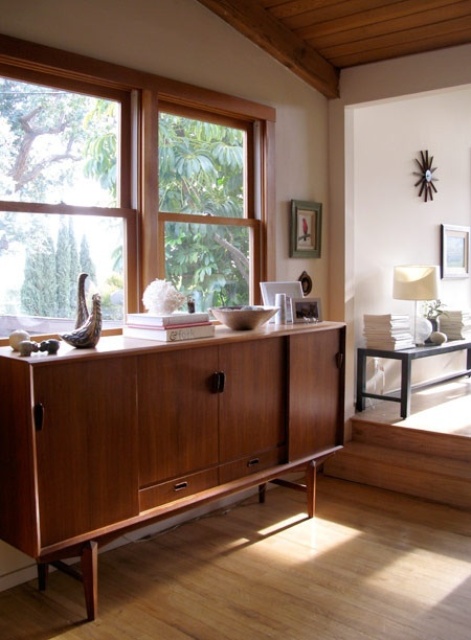 a dark-stained mid-century modern sideboard with doors and drawers, on tall legs is a stylish and timeless idea for a modern space