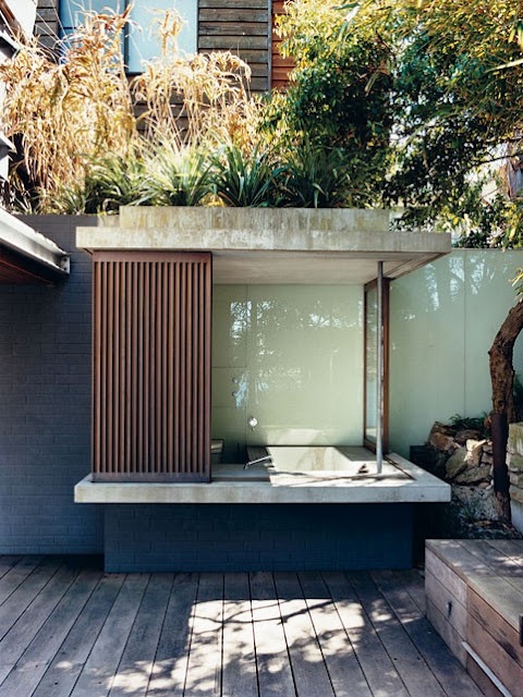an outdoor bathroom with a built-in concrete bathtub that can be completely hidden