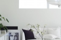 a black and white Scandinavian space refreshed with greenery and blooming branches in sheer vases is all cool