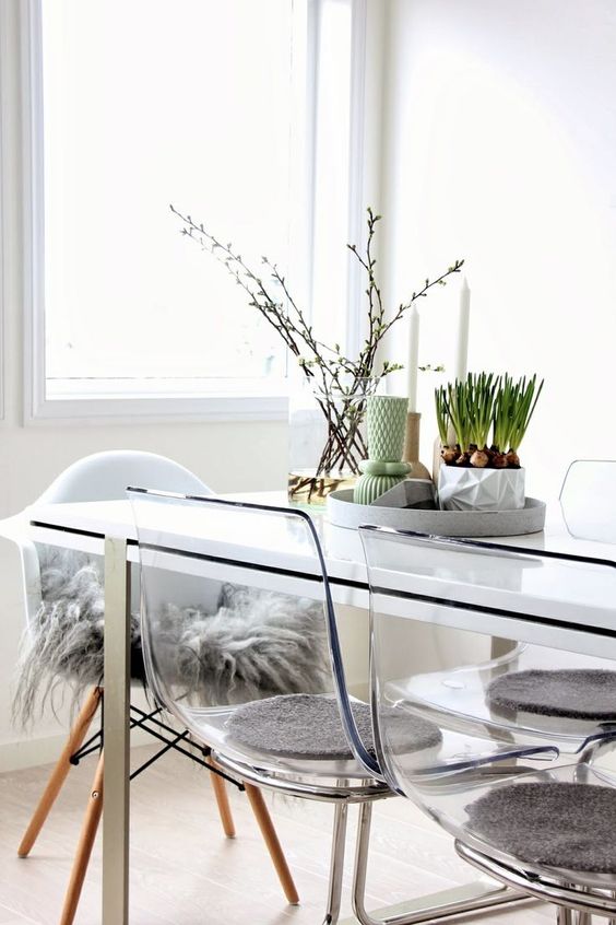 a Nordic spring centerpiece of a tray with some candleholders, potted bulbs ina  geo planter and a vase with blooming branches