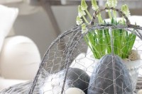Easter Scandinavian decor with a vine tray, hay and eggs – natural and fake ones, feathers and bulbs in a pot