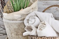 simple Nordic spring decor with a concrete planter with bulbs and twigs plus note paper and a basket with neutral towels