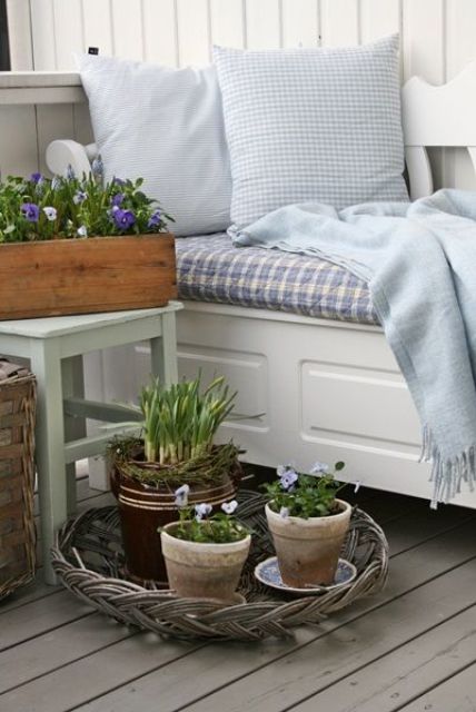 Nordic spring decor with potted pansies and bulbs in a woven tray, with blue printed textiles is very welcoming