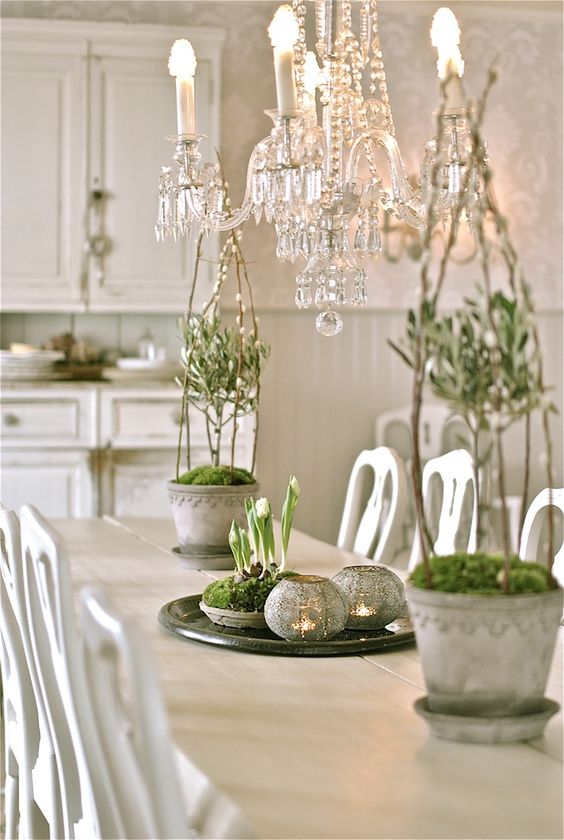 vintage Nordic decor with potted bulbs in moss, mercury glass candleholders, potted greenery with willow and moss