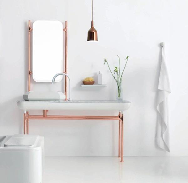 a serene neutral bathroom with a vanity on copper pipe legs and a mirror in a copper pipe frame is a lovely and serene space to be in