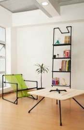 a bold modern nook with an exposed pipe shelving unit, a pipe and neon green twine chair, a coffee table or plywood and pipes is a cool space