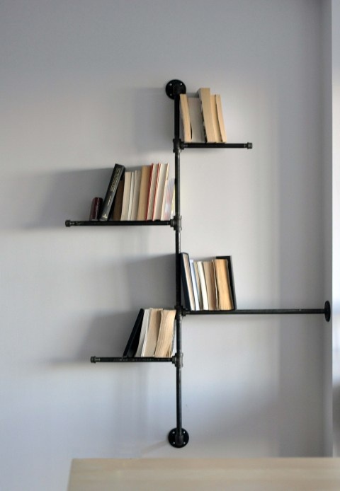 a black pipe shelving unit for books looks eye catchy and cool and makes the space a bit more industrial than it is
