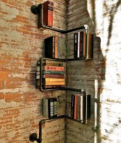 a corner black pipe shelving unit with books is a very eye-catchy and smart solution plus a lovely way to get use of your awkward corner