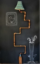 a wall lamp of copper pipes and with a green lampshade is a bold and creative solution for any space, especially if the wall is a chalkboard one and you may add art