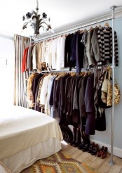 a makeshift closet built of pipes, with two tiers and shoes placed under it is a lovely idea for a small bedroom, if you have no separate closet