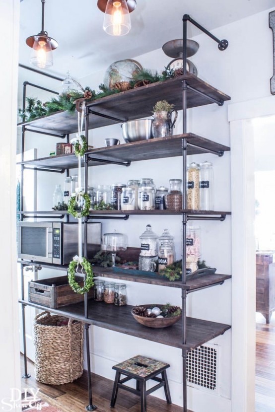 a large industrial shelving unit composed of exposed pipes and stained wood is a cool solution for an industrial or rustic pantry or kitchen