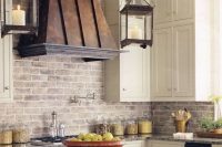a lovely white farmhouse kitchen with shaker style cabinets, a whitewashed brick backsplash, an aged metal hood is a beautiful and elegant space to be in