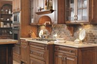 a vintage dark-stained kitchen with shaker style cabinets, white countertops, a brick backsplash and built-in lights looks elegant, chic and stylish