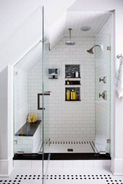 a black and white attic shower space with mosaic tiles, a bench and niches for storage
