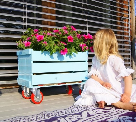 a blue crate on casters may be used to place some planters or any other stuff to store