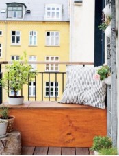 a plywood bench in the balcony with a storage space inside is a simple and comfy solution for a tiny balcony