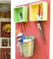 bright painted box shelves for tools and a metal bucket for storing are a creative idea for shed storage