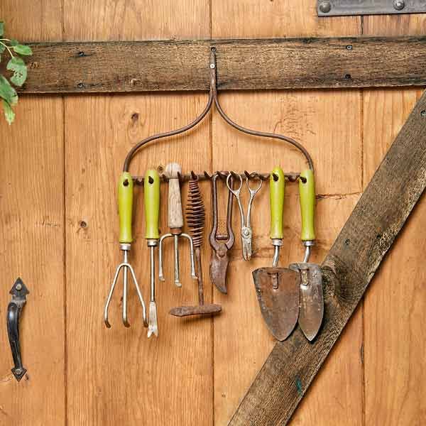 attach a piece of rake to the wall to use it as a holder and hanger for your tools