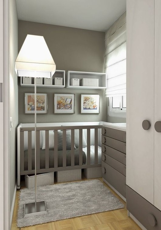 a grey and white small nursery with a built-in crib and a grey dresser that doubles as a changing table and shelves with baskets for storage