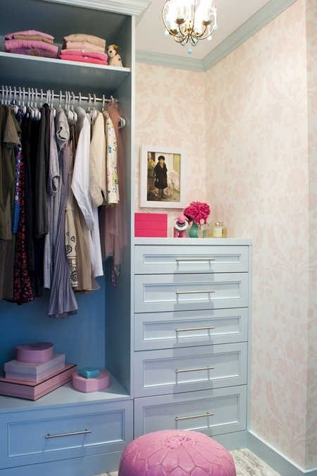 a pastel mini closet with blue built-in furniture, open and closed storage units, pink touches here and there