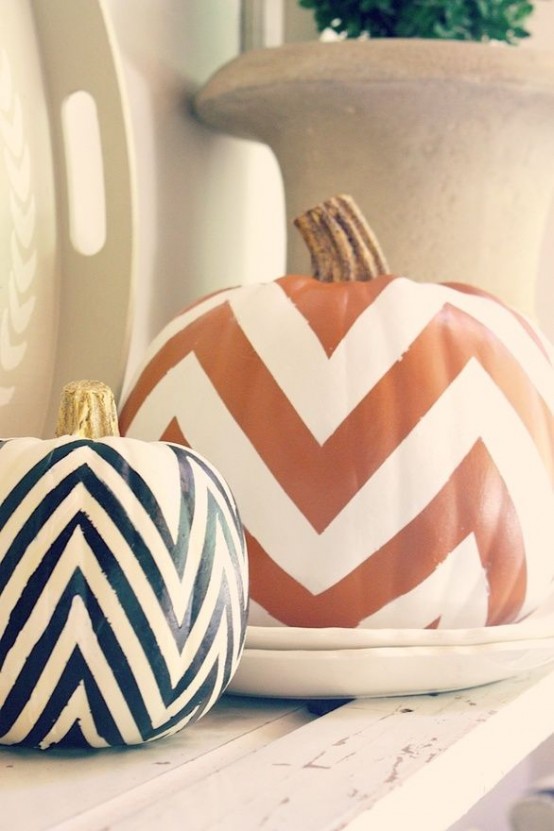 two pumpkins with orange, black and white chevrons can decorate any mantel in a stylish mid-century modern way