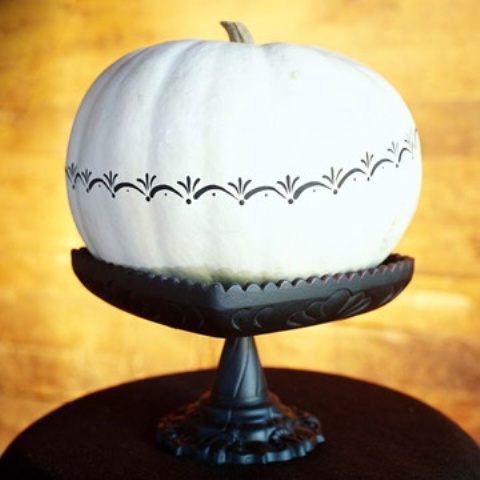 a white pumpkin decorated with black patterns is a stylish and chic decoration for Halloween