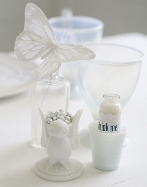 a stand with white candies, a white drink and a white butterfly are great for elegant and delicate Halloween styling
