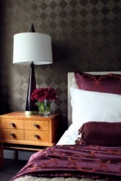 a purple table lamp and bedding are nice accents for this dramatic bedroom, and blooms match, too