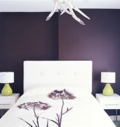 a purple bedroom with white furniture, table lamps with green bases and a quirky chandelier looks unique and statement-like