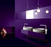 a dramatic sleek purple bathroom with a floating vanity, a long mirror, pendant lamps and a fireplace