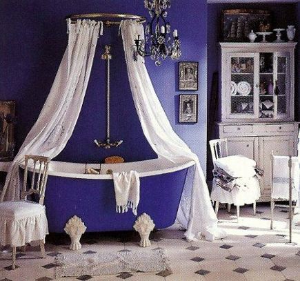 a vintage-inspired purple and white bathroom with a mosaic tile floor, a canopy of curtains and a white buffet