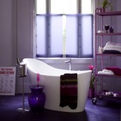 a contemporary bathroom with a purple tile floor, a fuchsia stand on casters, lavender shades and a catchy contemporary bathtub