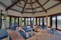 quite functional sunroom gym with a bunch of cool exercise machines