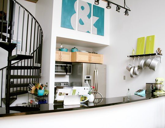 a small white kitchen with all the necessary appliances and a bar countertop for cooking and eating
