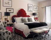 a neutral bedroom with a black and white printed rug, a printed chair, stained nightstands and black table lamps